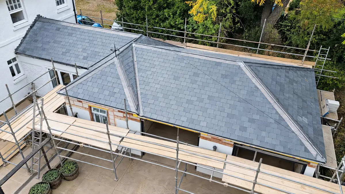 Aerial view of a natural slate hip roof with new lead hips, scaffolded during works