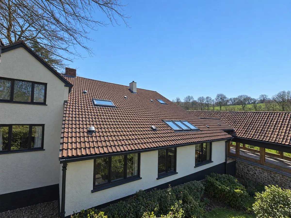 Double roman tiled roof with Velux rooflights on a rendered house